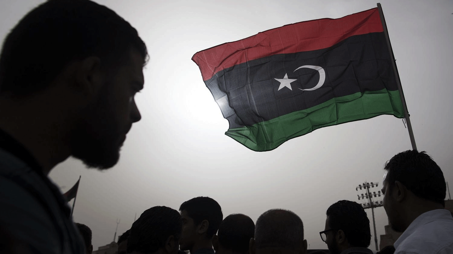 مقاتلون ينتمون لقوات الحكومة المدعومة دوليا يرفعون علم ليبيا خلال جنازة أحد المقاتلين، 24 أبريل 2019