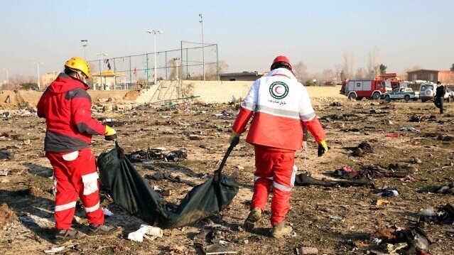 أحد فرق الإنقاذ يلملم أشلاء ضحايا الطائرة الأوكرانية المنكوبة في إيران في 8 يناير 2020