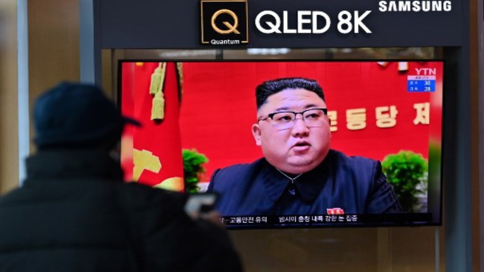 رجل يشاهد شاشة تلفزيون تعرض لقطات إخبارية للزعيم الكوري الشمالي كيم جونغ أون أثناء حضوره المؤتمر الثامن لحزب العمال الحاكم الذي عقد في بيونغ يانغ ، في محطة سكة حديد في سيول في 6 يناير 2021