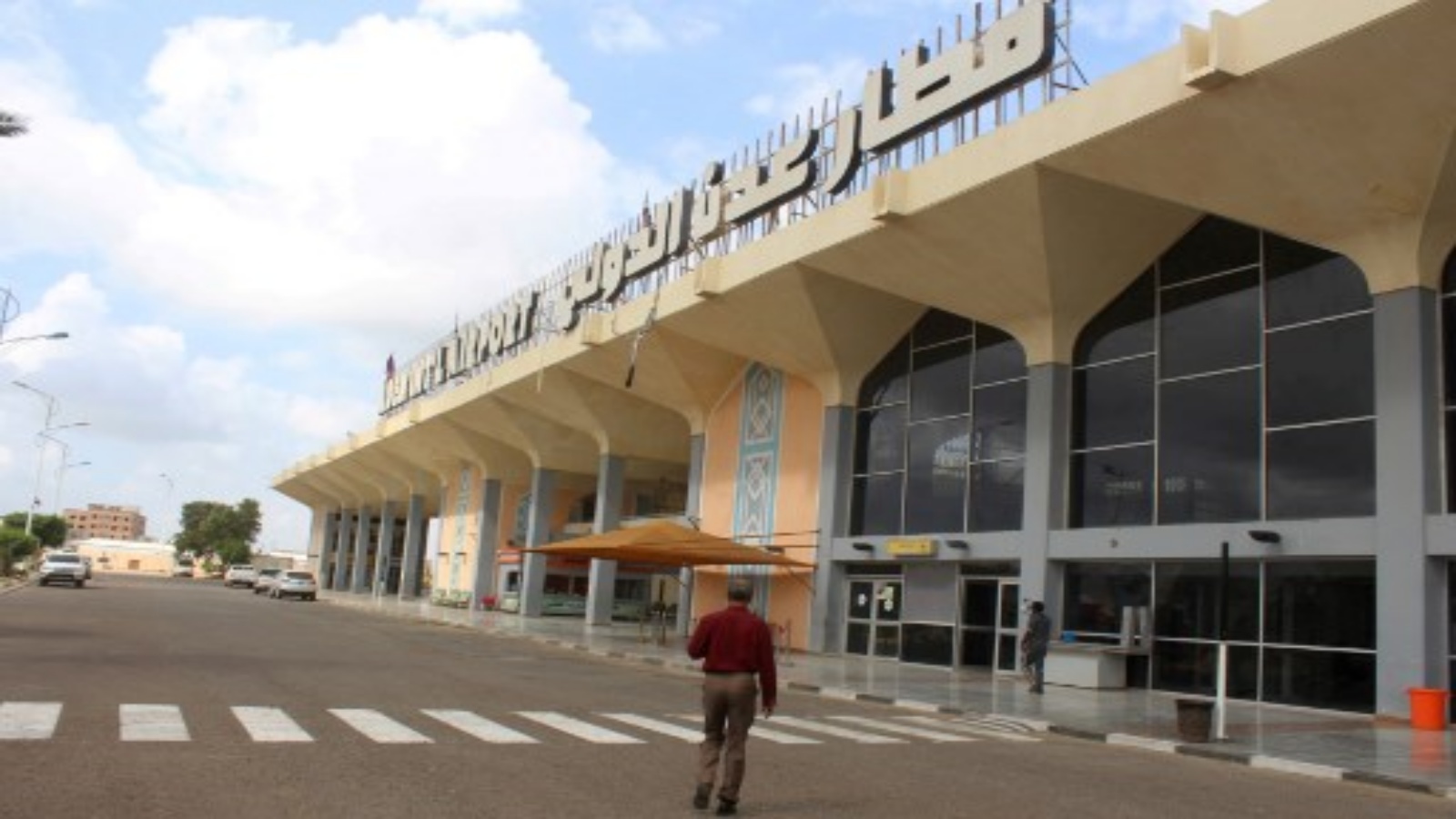 رجل يسير إلى مبنى المطار في مدينة عدن جنوب اليمن في 3 يناير / كانون الثاني 2021 ، مع استئناف النشاط بعد أن هزت انفجارات المبنى في 30 ديسمبر مما أسفر عن مقتل وإصابة العشرات.