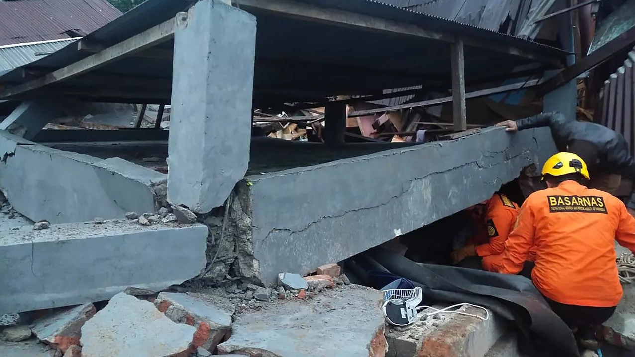 رجال الإنقاذ يبحثون عن ناجين محاصرين في مبنى منهار في ماموجو ، عاصمة سولاويزي ، بعد الزلزال الذي وقع ليلاً.