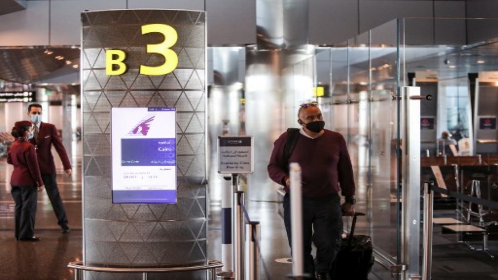 مسافر يرتدي قناعا يصل إلى البوابة على متن أول رحلة للخطوط الجوية القطرية متجهة إلى القاهرة بعد استئناف الرحلات بين قطر ومصر ، في مطار حمد الدولي في قطر بالقرب من العاصمة الدوحة في 18 يناير 2021