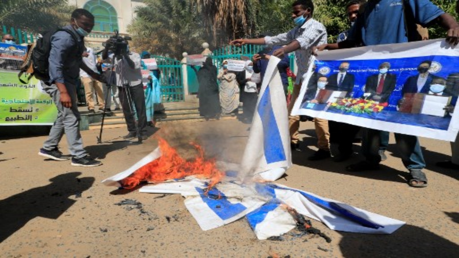 متظاهرون سودانيون يحرقون الأعلام الإسرائيلية خلال مسيرة ضد توقيع بلادهم مؤخرًا على اتفاق لتطبيع العلاقات مع الدولة اليهودية ، خارج مكاتب مجلس الوزراء في العاصمة الخرطوم ، في 17 يناير 2021.