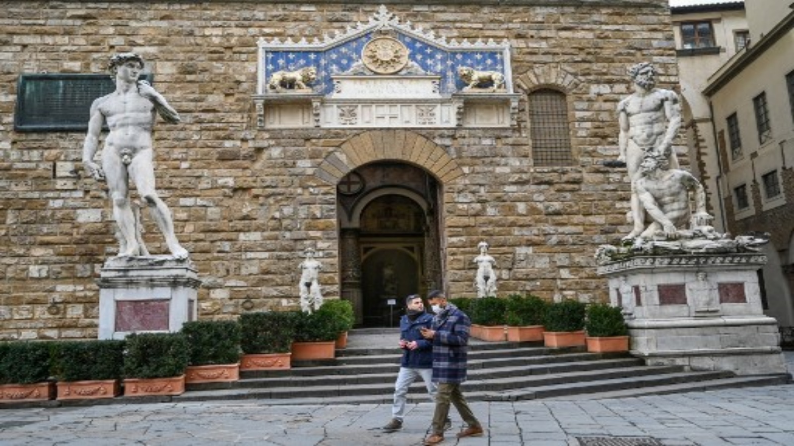 يمشي الناس بجوار Palazzo della Signoria ، أمام نسخة من مايكل أنجلو 