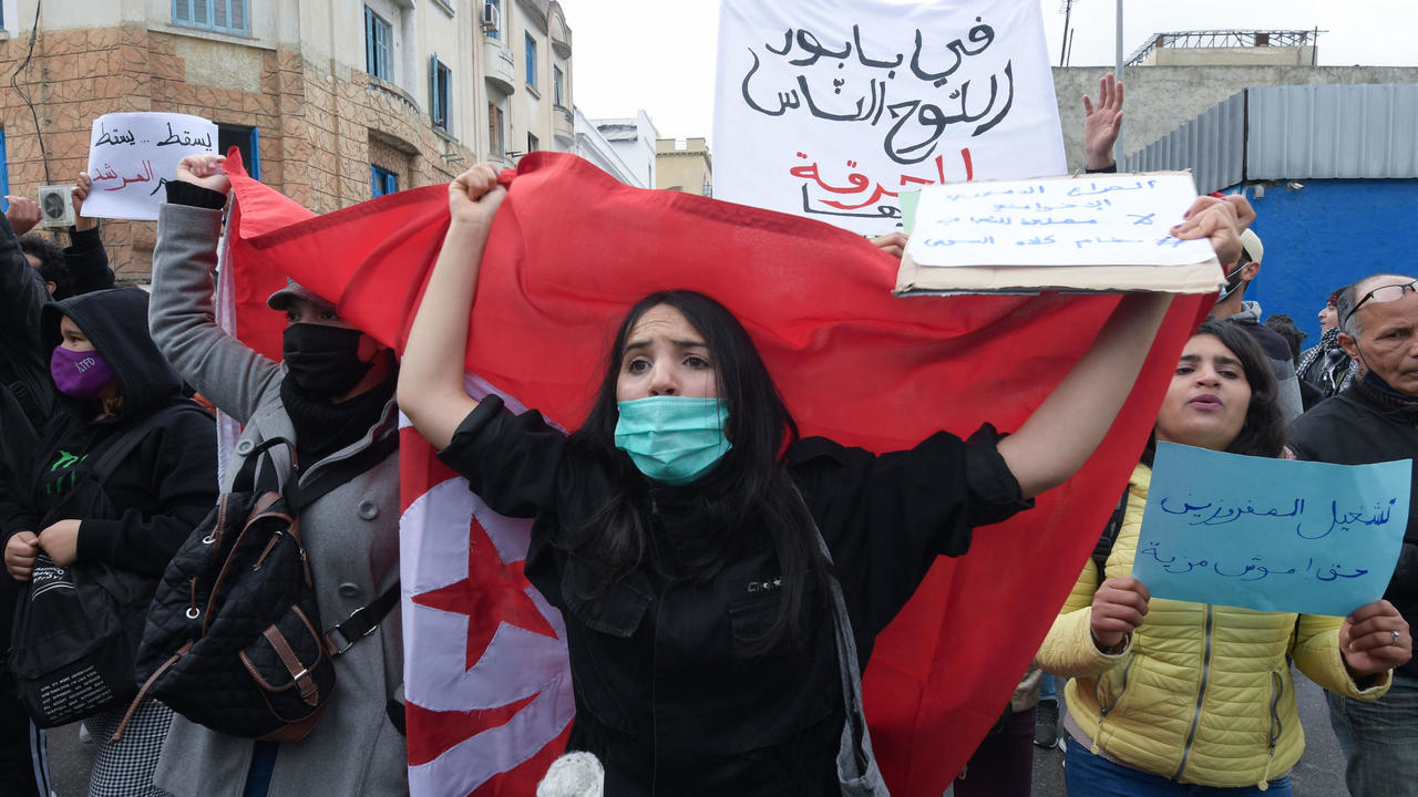 متظاهرة تونسية ترفع علم البلاد خلال تظاهرة ضد الحكومة في العاصمة تونس بتاريخ 23 كانون الثاني/يناير 2021