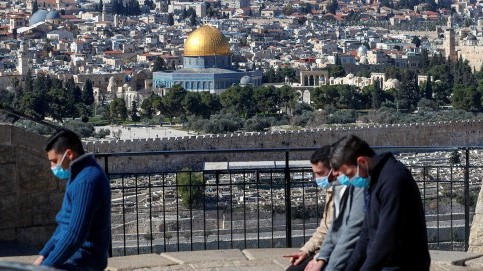 فلسطينيون يصلون ويظهر مسجد الأقصى