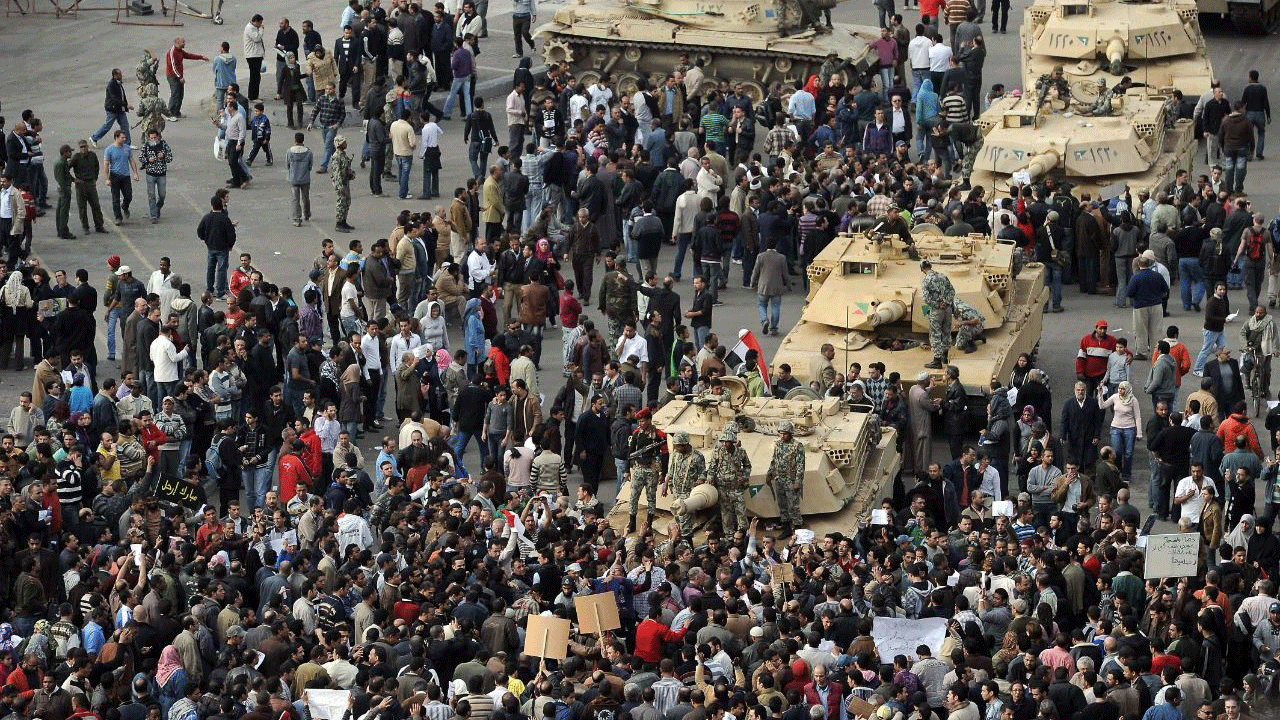 متظاهرون مصريون تجمعوا حول دبابات للجيش تمركزت في ميدان التحرير في القاهرة في اليوم السادس من الثورة الغاضبة ضد نظام مبارك الموافق 30 كانون الثاني/يناير 2011