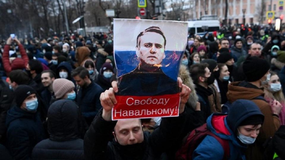 مؤيد للمعارض الروسي أليكسي نافالني يحمل صورته في تظاهرة في موسكو
