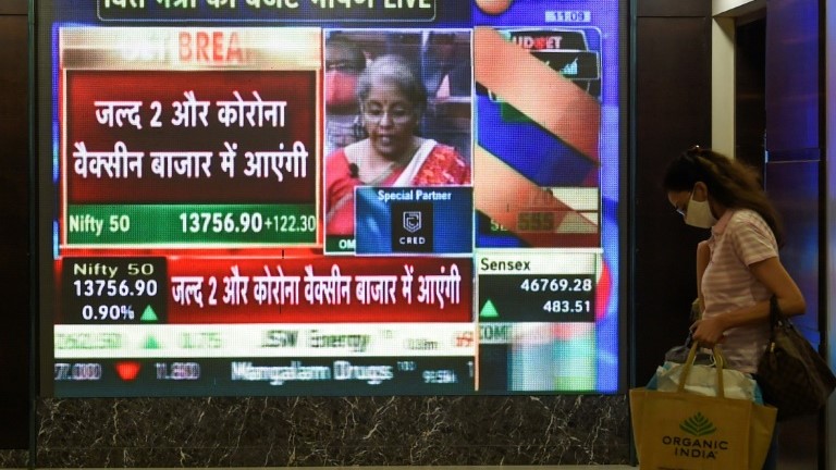 موظفة تمر من أمام شاشة تظهر وزيرة المالية الهندية نيرمالا سيتارامان في بومباي الإثنين