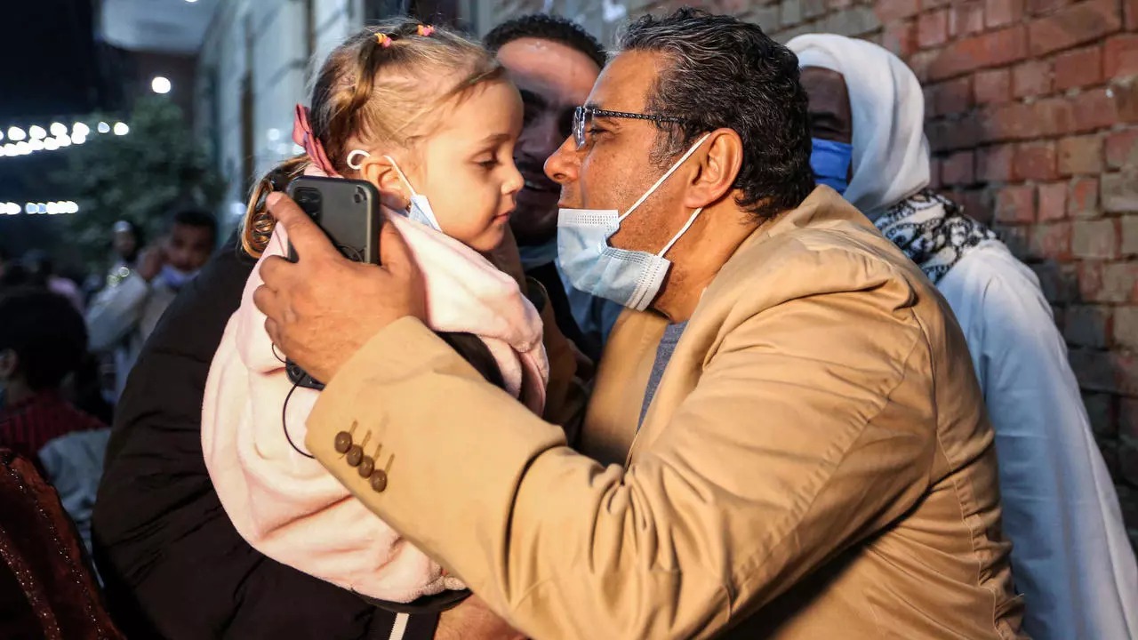 الصحافي المصري في قناة الجزيرة القطرية محمود حسين يقبل طفلة لدى وصوله إلى منزله في القاهرة اليوم 