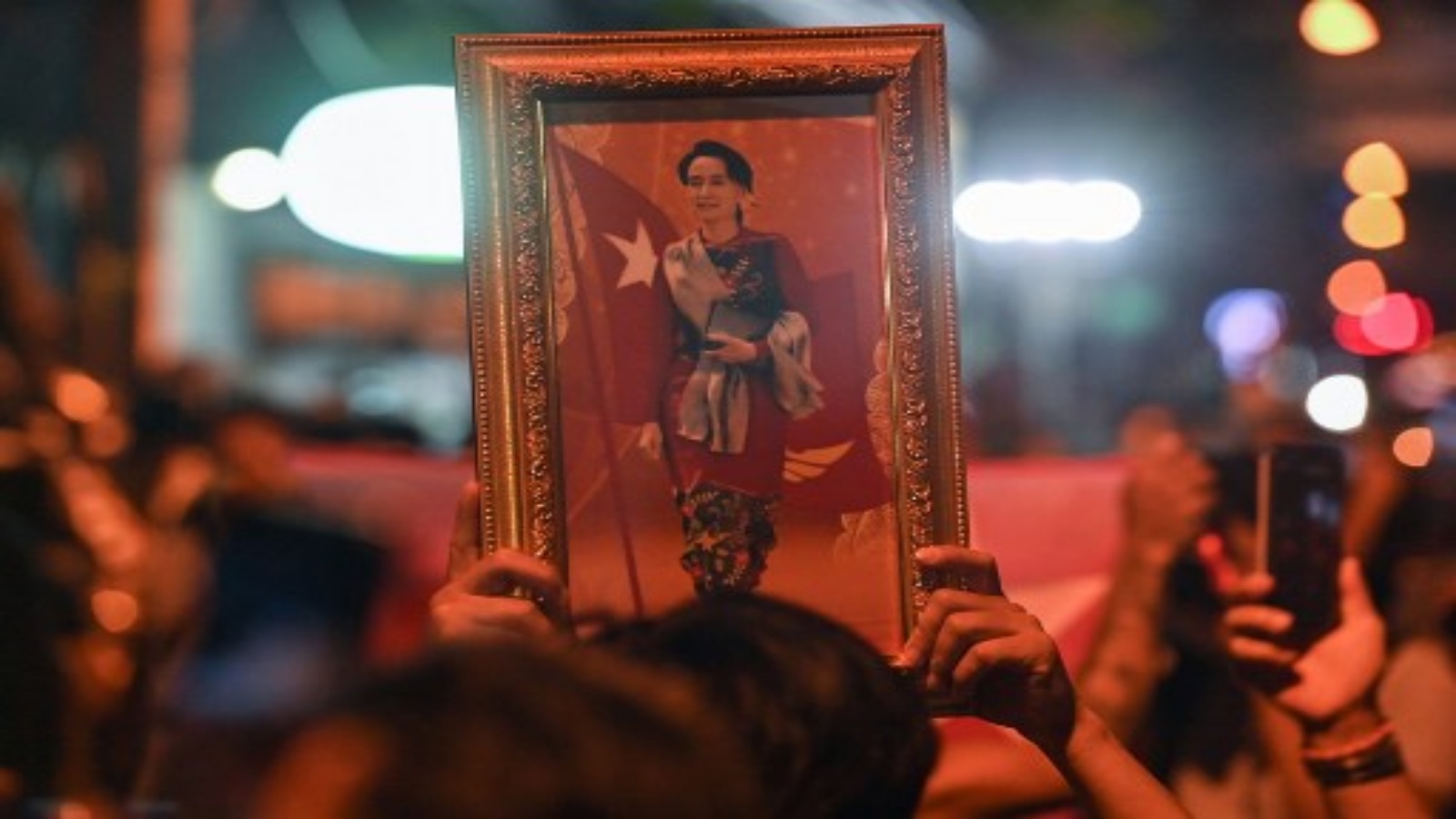 متظاهر يحمل صورة مؤطرة للزعيم المدني الميانماري المحتجز أونغ سان سو كي خلال مظاهرة تدين الانقلاب العسكري خارج سفارة ميانمار في بانكوك في 4 فبراير 2021 ، بعد أيام من اعتقال قوات الأمن الميانمارية لسو كي ورئيس البلاد.