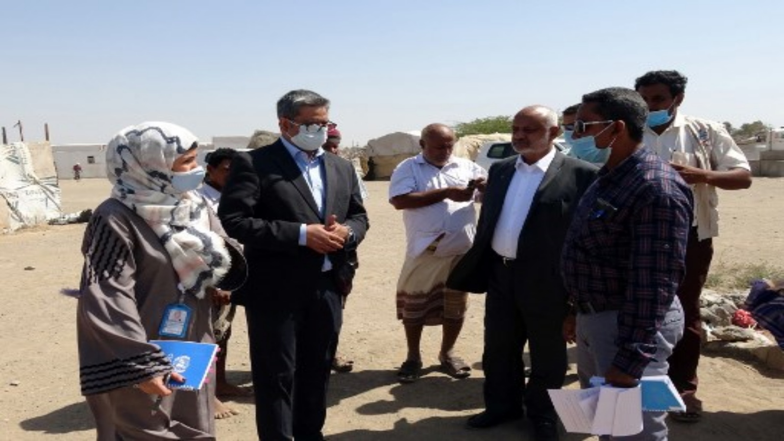 سجاد محمد (2-يسار) ، ممثل مكتب تنسيق الشؤون الإنسانية (OCHA) ، يزور مخيمات النازحين داخليًا في محافظة الحديدة غرب اليمن في 4 فبراير 2021