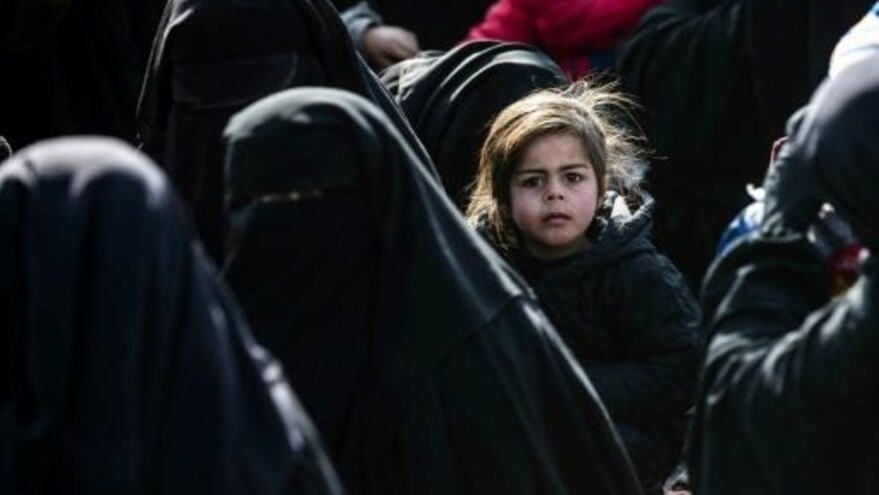 طفلة تتوسط عدداً من النساء السوريات داخل مخيم الهول، الذي يؤوي نازحين وعائلات مقاتلي تنظيم الدولة الإسلامية في شمال شرق سوريا، خلال استعدادهن للمغادرة في 28 يناير 2021 باتجاه مناطقهم