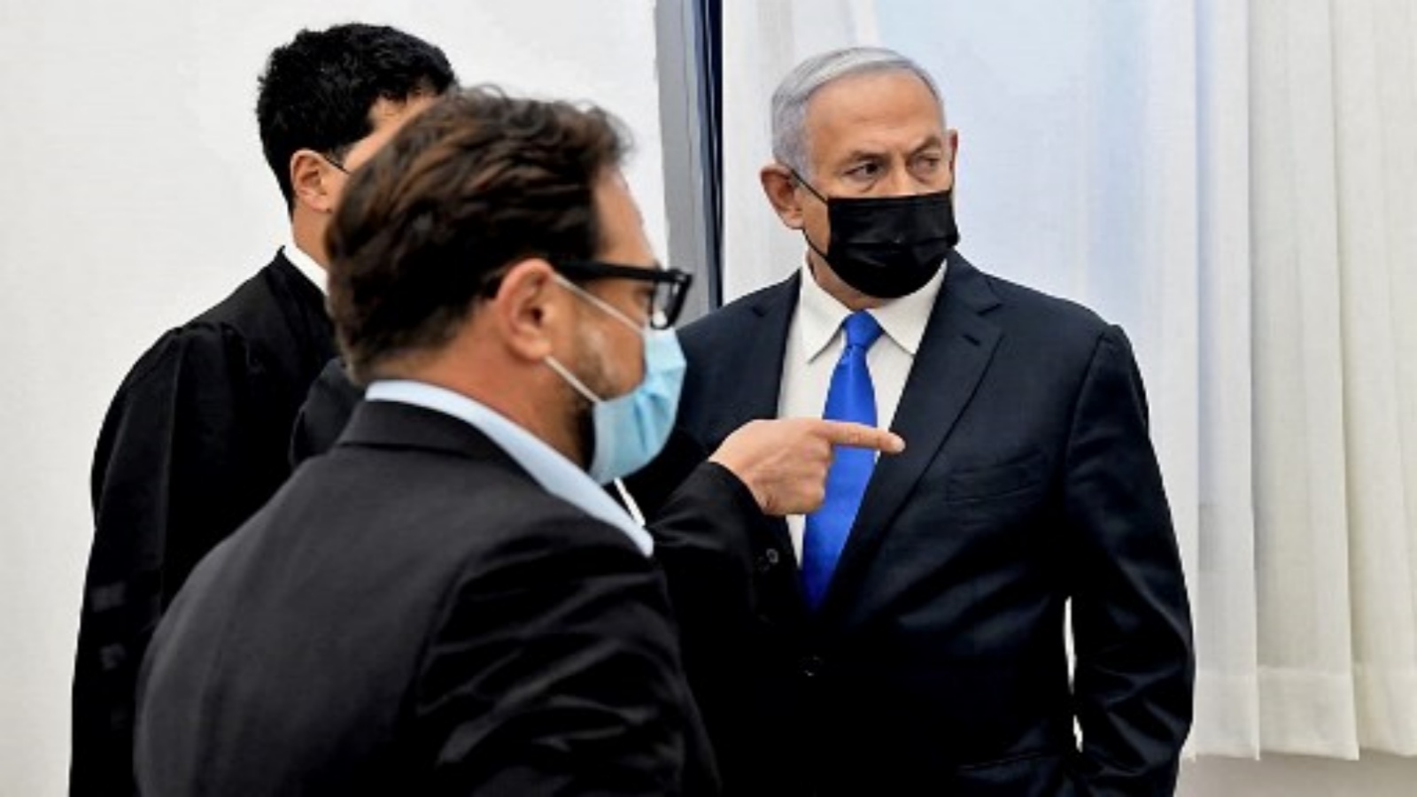 رئيس الوزراء الإسرائيلي بنيامين نتنياهو (يمين) يتحدث إلى محاميه قبل جلسة استماع في محاكمة فساد في محكمة القدس الجزئية ، في 8 فبراير 2021