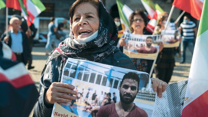 امرأة تحمل صورة المصارع الإيراني نويد أفكاري خلال مسيرة احتجاجية في ساحة دام في أمستردام ضد إعدامه في شيراز جنوب إيران