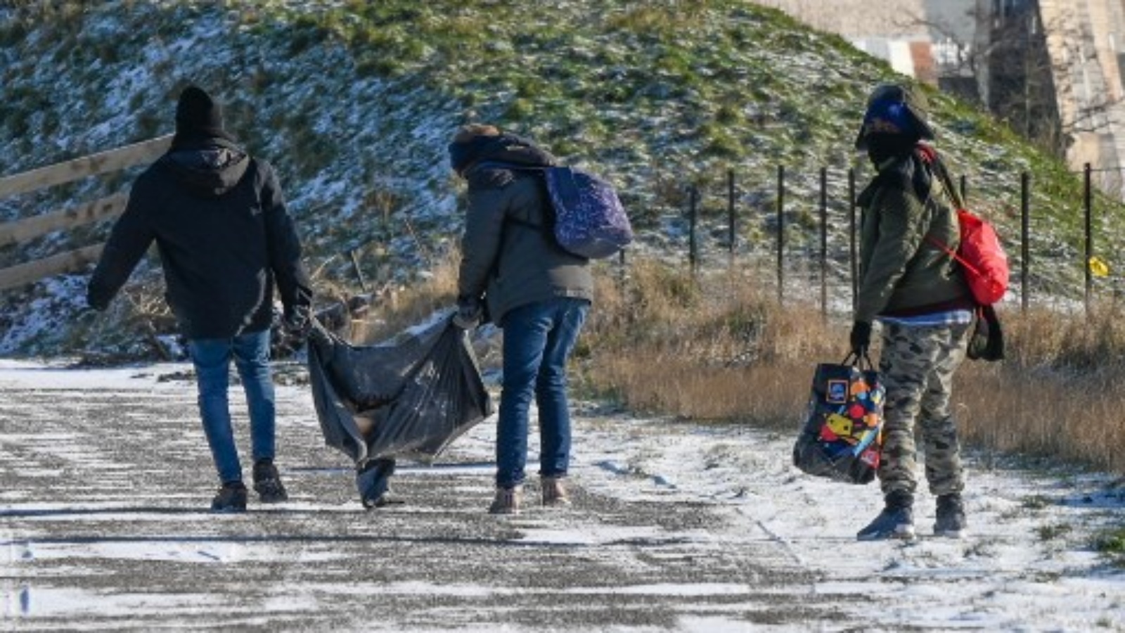 مهاجرون يسيرون للحصول على وجبات توزعها الجمعيات في كاليه ، شمال فرنسا ، في 9 فبراير 2021. أعلنت ولاية الشمال عن 170 مكان إقامة 