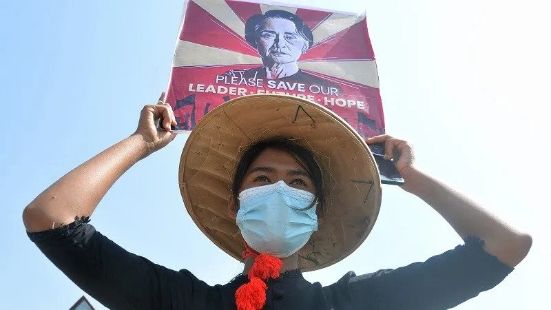 متظاهرة بورمية ترفع صورة أونغ سان سو تشي التي يعتلها الجيش منذ قيامه بانقلاب عسكري