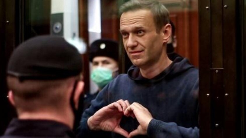  المعارض الروسي أليكسي نافالني في قفص زجاجي أثناء جلسة محاكمة في موسكو، يجمع يديه بشكل قلب، في 2 فبراير 2021 في صورة وزعها مكتب الإعلام في محكمة موسكو 