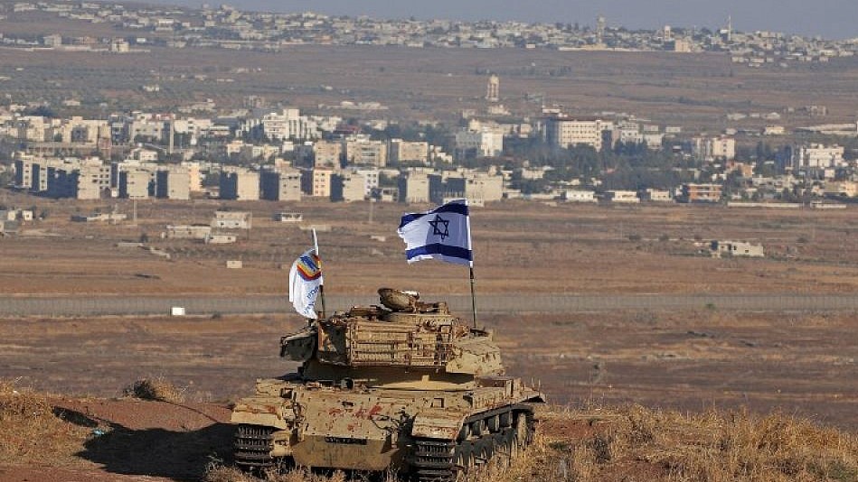 علم إسرائيلي يرفرف فوق حطام دبابة على تل في هضبة الجولان المطلة على الحدود مع سوريا في 18 أكتوبر 2017