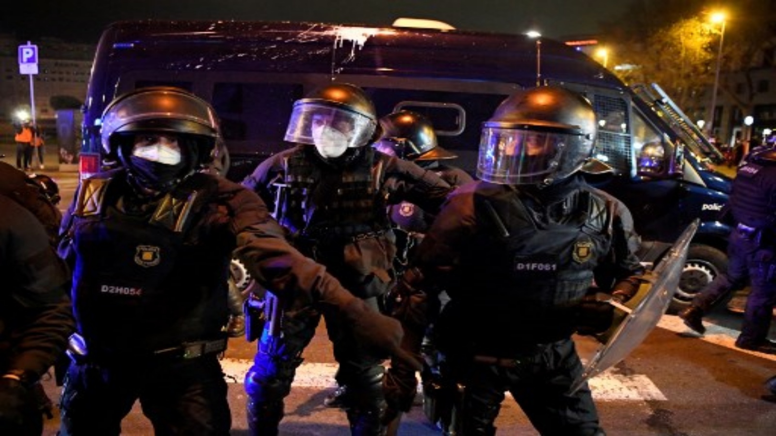 عناصر من قوات الشرطة الإقليمية الكتالونية موسوس دي إسكوادرا يقفون في حراسة خلال الاشتباكات التي أعقبت مظاهرة ضد سجن مغني الراب الإسباني بابلو هاسل في برشلونة في 21 فبراير 2021.