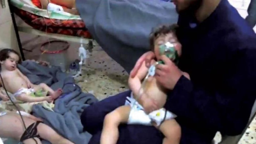 صورة من الأرشيف تبين متطوعًا يسعف طفلاً مصاباً بالاختناق جراء القصف الكيماوي على دوما في الغوطة الشرقية 