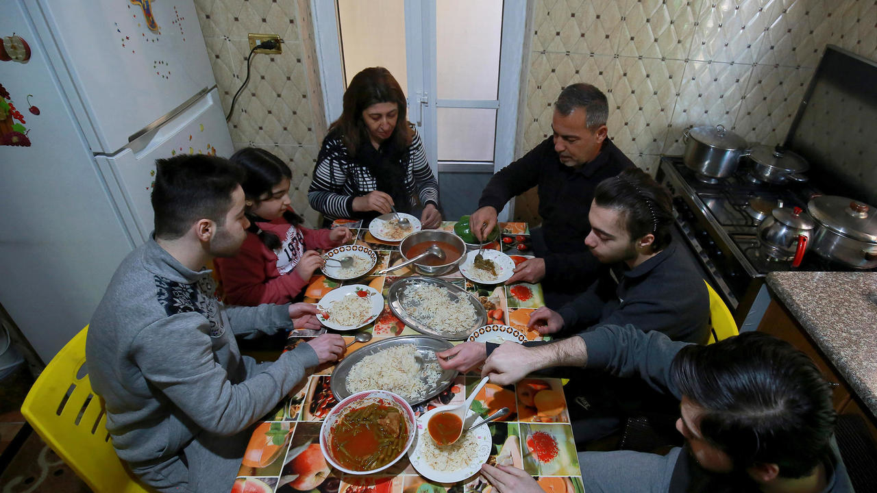 اللاجئ العراقي المسيحي سعد هرمز يجلس مع زوجته وابنائه في عمان في 24 كانون الثاني/يناير 2021 حيث يقيمون منذ 2018 بعد فرارهم من مدينتهم الموصل