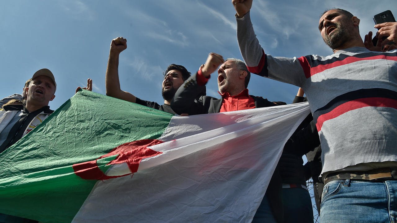 جزائريون يحملون علم بلادهم خارج سجن القليعة قرب مدينة تيبازة غرب العاصمة الجزائر بتاريخ 19 شباط/فبراير 2021