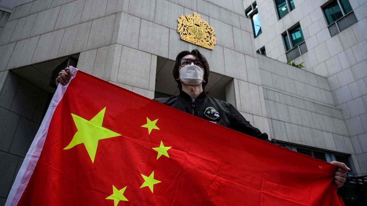 رجل يرفع علم الصين خلال تظاهرة لمؤيدين لبكين أمام القنصلية البريطانية العامة في الصين في 1 شباط/فبراير 2021