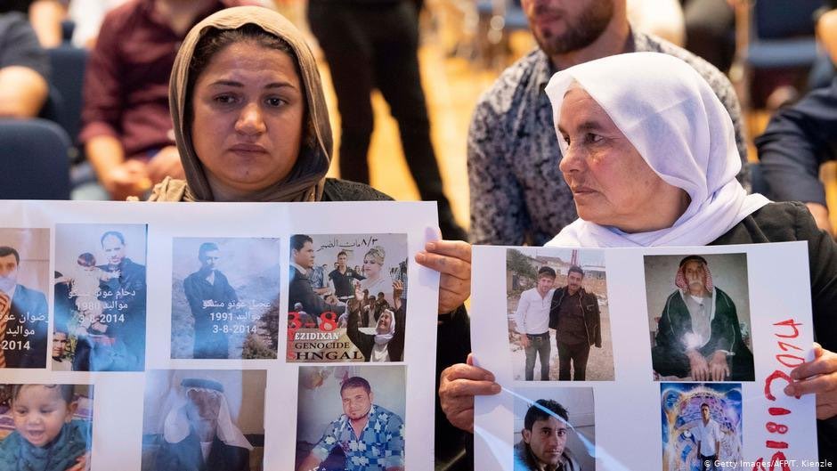 ايزيديتان تحملان صور مغيبين على يد داعش من افراد عائلاتهما