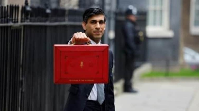 وزير الخزانة البريطاني ريشي سوناك يحمل حقيبة تحتوي على ميزانية البلاد، لدى خروجه من 11 داونينغ ستريت قبل عرضه الميزنية على البرلمان البريطاني في 3 مارس 2021 في لندن