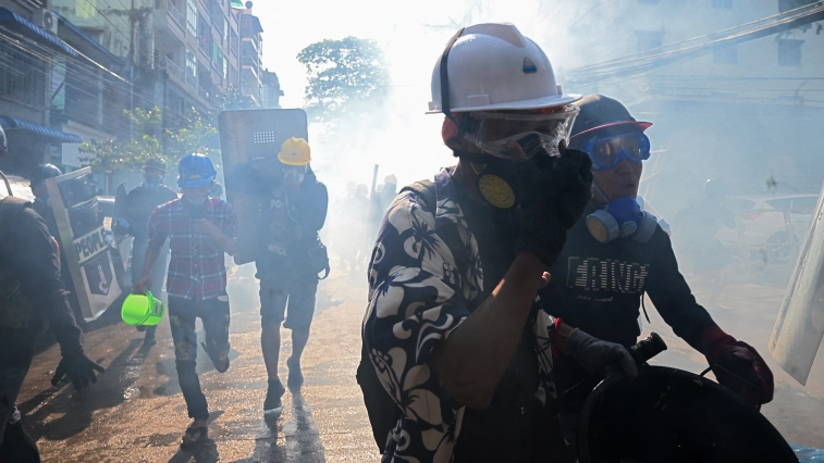متظاهرون يرتدون أقنعة واقية من الغازات المسيلة للدموع