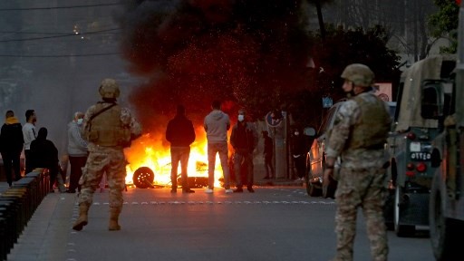 دورية للجيش اللبناني متوقفة أمام طريق في صيدا قطعه المحتجون بالإطارات المشتعلة الإثنين