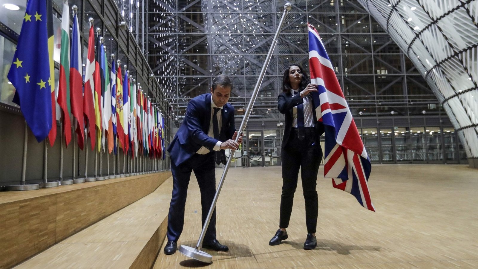 موظفان في مجلس الاتحاد الأوروبي ينزعان علم المملكة المتحدة من مبنى المجلس الأوروبي في بروكسل في 31 يناير 2020