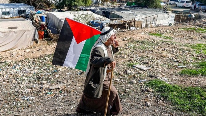 فلسطيني يحمل علم فلسطين في خان الأحمر بالضفة الغربية في 29 نوفمبر 2020