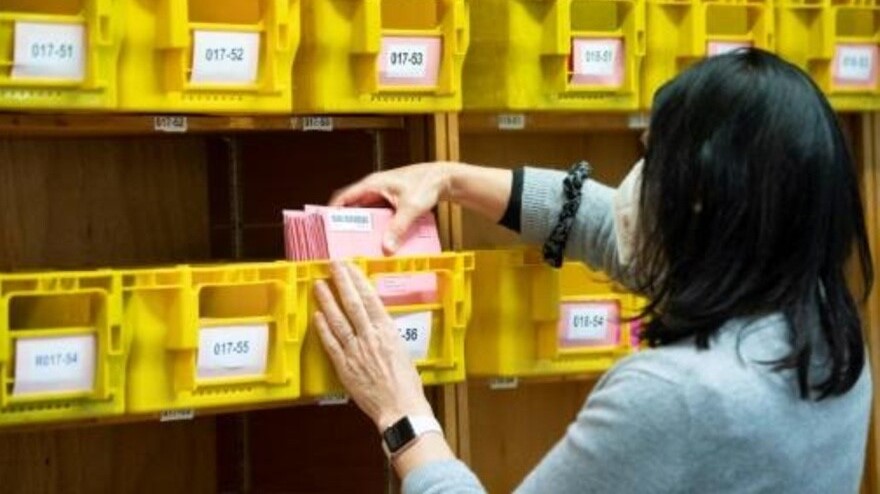 موظفة في مكتب الإحصاءات تفرز بطاقات الاقتراع الواردة عبر البريد بحسب أرقام الدوائر في انتخابات محلية في 2 آذار/مارس 2021 في شتوتغارت بغرب ألمانيا