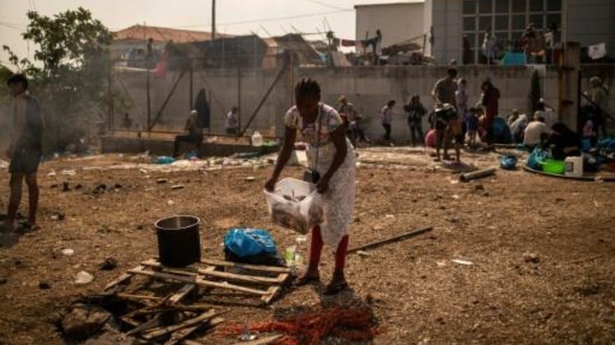 مهاجرة تحضر الطعام قرب مخيم موقت على جزيرة ليسبوس اليونانية في 15 أيلول/سبتمبر 2020 