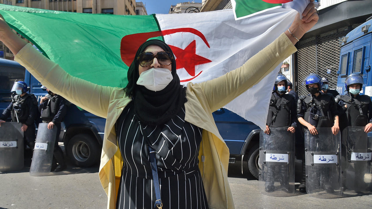 متظاهرة من الحراك يرفع العلم الجزائري في العاصمة الجزائرية في 26 آذار/مارس 2021