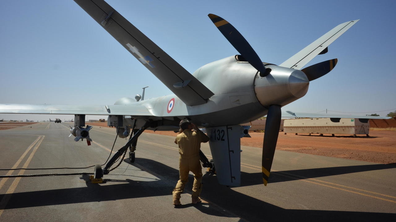 طيار فرنسي يكشف على طائرة مسيّرة مسلّحة من طراز ريبر قبل إقلاعها من قاعدة عملية برخان العسكرية في نيامي في النيجر في 15 كانون الأول/ديسمبر 2019