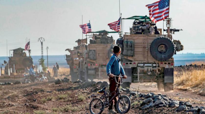 صبي يراقب قافلة تابعة للجيش الأميركي في منطقة الشمال الشرقي السوري