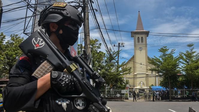 شرطي إندونيسي يقف أمام كنيسة ماكاسار التي وقع فيها الانفجار الأحد