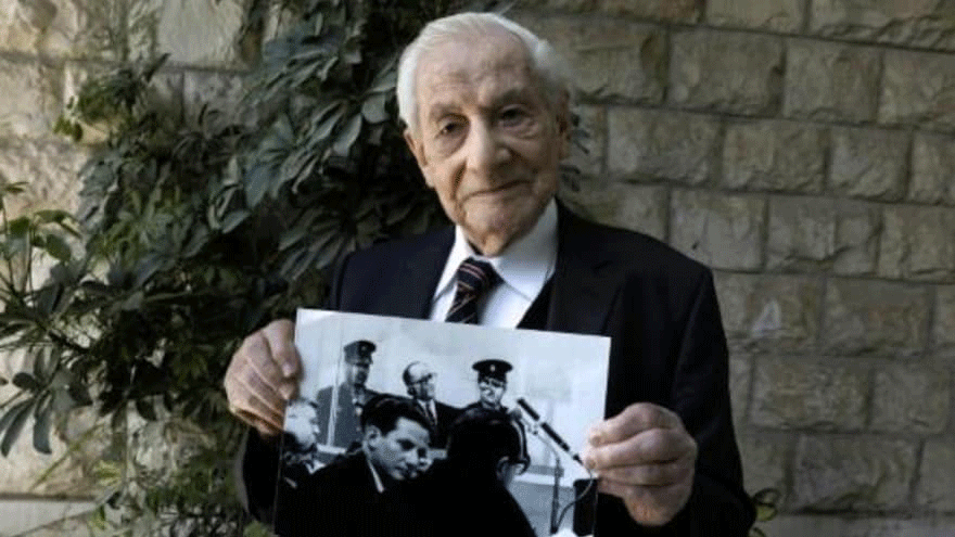 غابرييل باخ (93 عاما) نائب مدعي عام سابق في إسرائيل أشرف على التحقيق مع النازي أدولف أيخمان ويحمل صورة له خلال المحاكمة في 1962