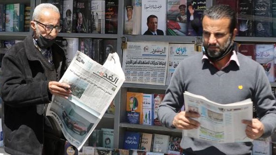 مواطنان يتابعان الصحف الأردنية