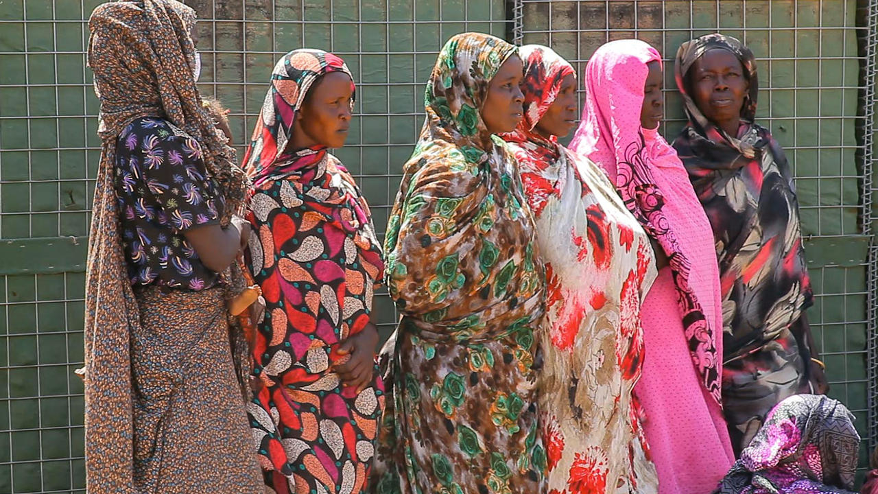نساء يشاهدن بعثة الأمم المتحدة والاتحاد الأفريقي لحفظ السلام في منطقة دارفور السودانية (يوناميد) تسلم مقرها للحكومة السودانية في خور أبشي، على بعد 120 كيلومترًا شمال نيالا عاصمة ولاية جنوب دارفور، في 15 شباط/فبراير 2021 