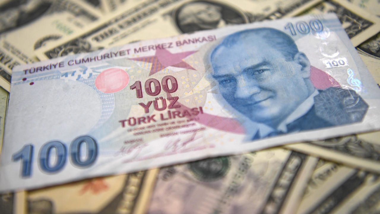 دولارات مع ورقة نقدية من الليرة التركية