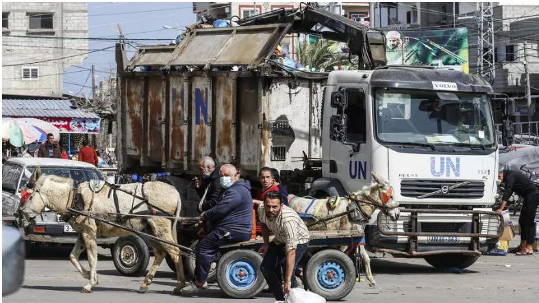 عمال الاونروا ينظفون شارع في مخيم رفح للاجئين في قطاع غزة