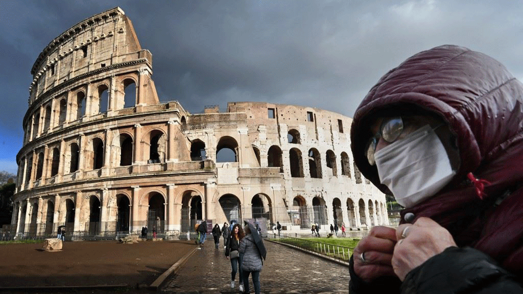 لابس كمامة يمر أمام الكولوسيوم في روما
