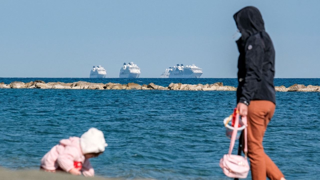 امرأة تراقب طفلاً يلعب على الشاطئ في مدينة ليماسول جنوب قبرص في 30 مارس 2021