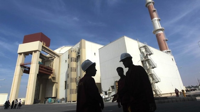 عاملون أمام بناء محطة بوشهر للطاقة النووية جنوب إيران