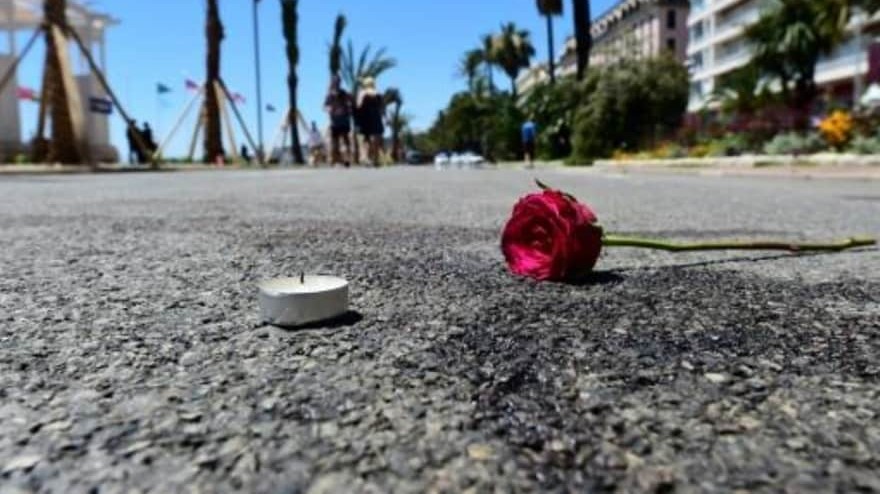 وردة وشمعة وضعتا عند بقعة دم في موقع الهجوم دهسا بشاحنة في مدينة نيس الفرنسية، في صورة التقطت في 16 تموز/يوليو 2016