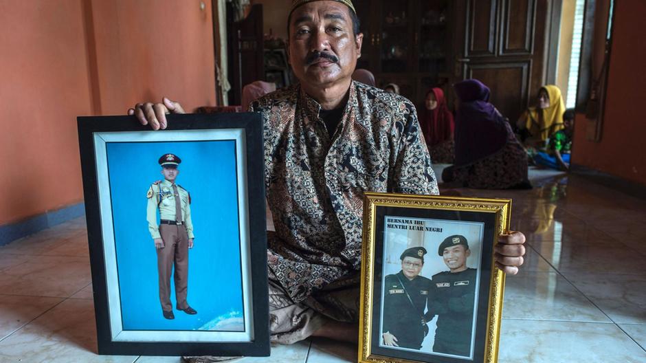 إيدي سوجيانتو يعرض صورًا لابنه الملازم أول محمد إمام عدي الذي كان يخدم على متن الغواصة الإندونيسية 'KRI Nanggala 402' عندما فُقدت في 21 أبريل